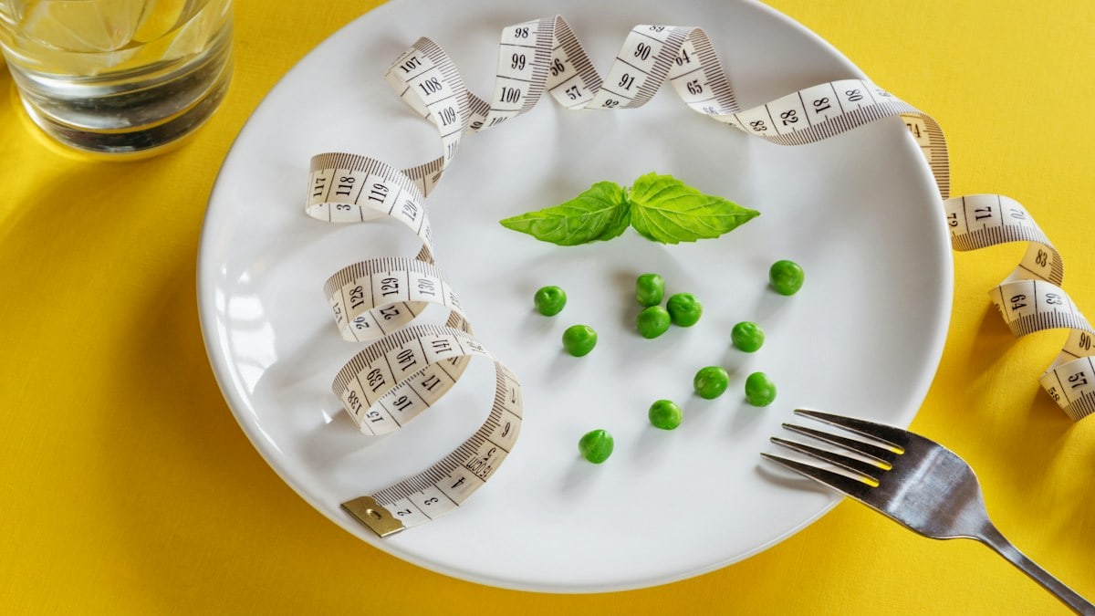 Diet white plate with centimeter peas and basil